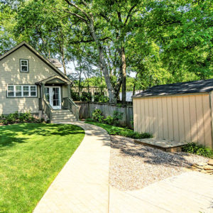 A naturally light yard with a new path leading from the house to the shed addition.