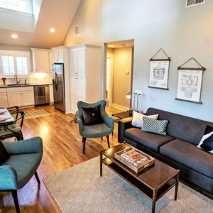 A well lit open space kitchen, dining, and living room.