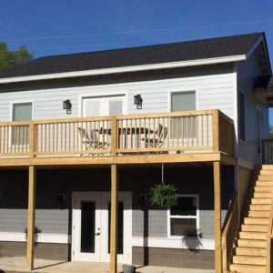 A two story house with a new second floor deck and stair addition.