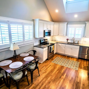 A well lit open space kitchen addition with dining room space.