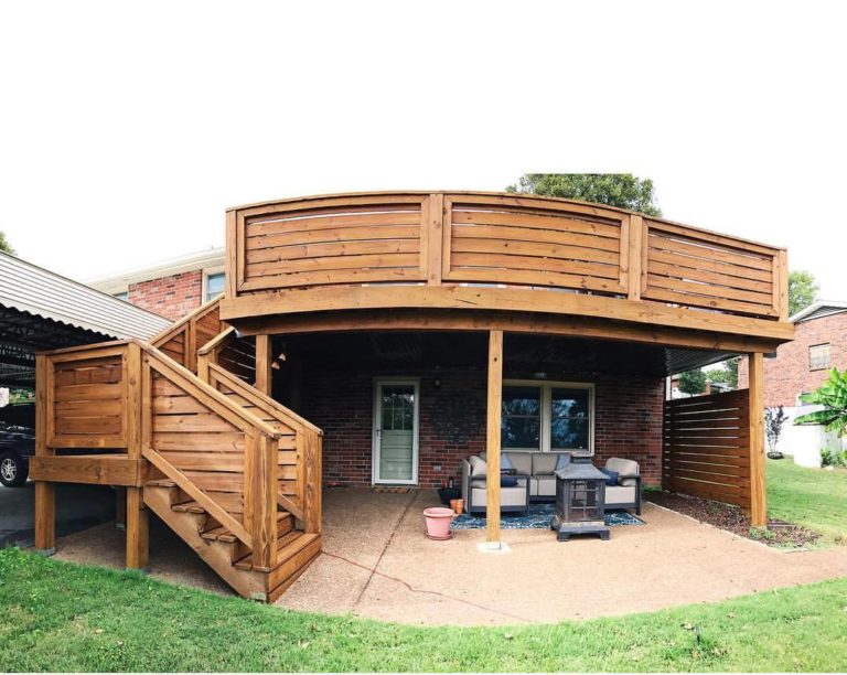 A wood deck on a second story with a door to a brick house underneath