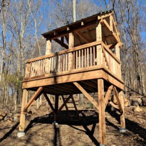 A wooden tree house with bare trees around it