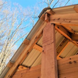 The top of a wooden tree house with bare trees around it