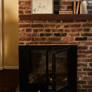 Brick fireplace with a shelf of books above