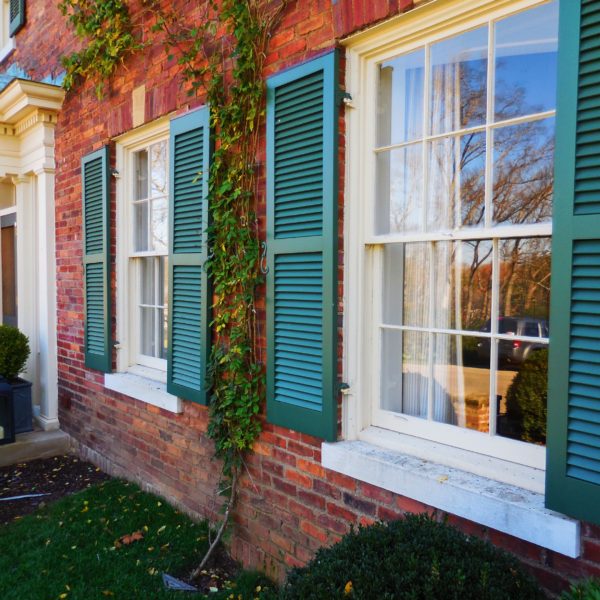 brown brick house with green rudders