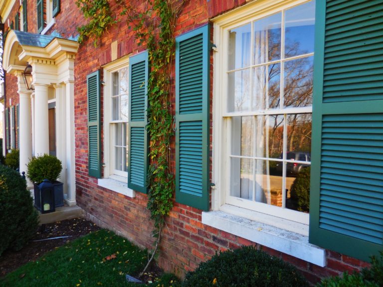 brown brick house with green rudders