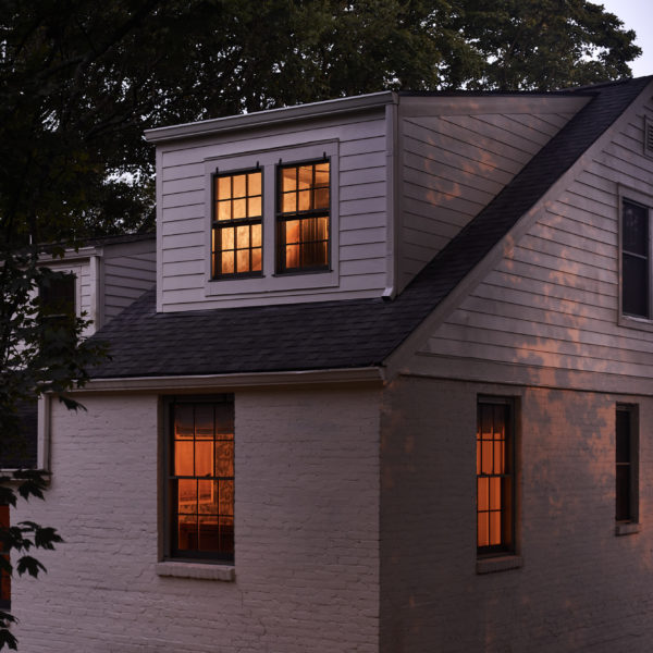 white brick house with windows at night