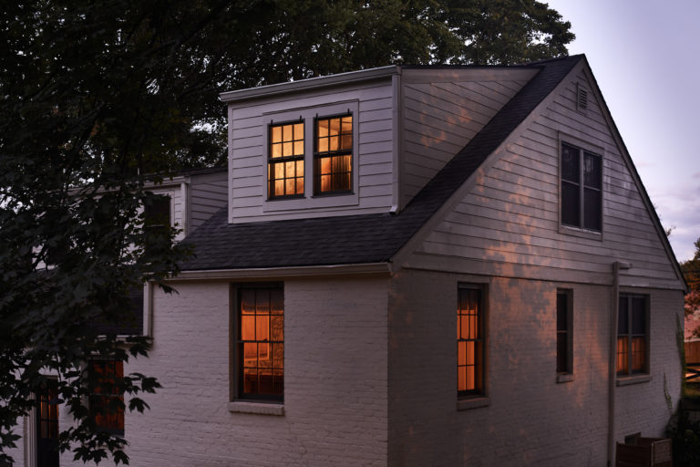 white brick house with windows at night