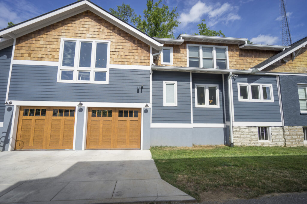 Blue and beige two-story home with a double garage and driveway.