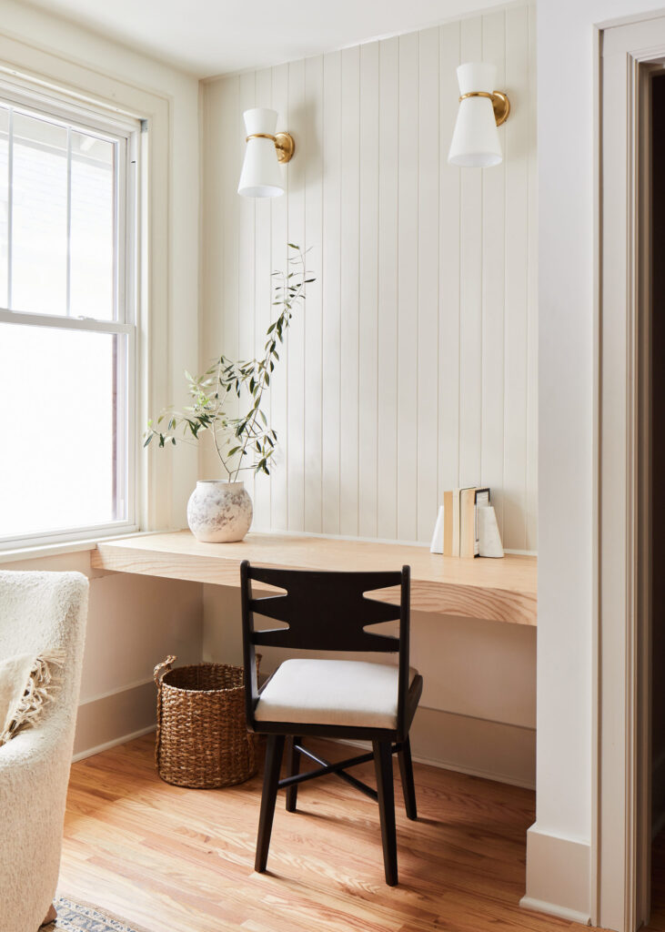 Built-in desk workspace with a wooden surface and modern wall-mounted lights.