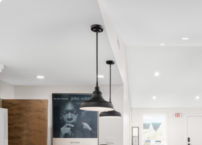 Kitchen lighting update featuring modern pendant lights and high ceilings.