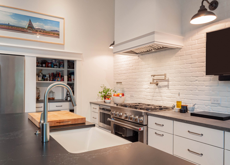 Modern kitchen with brick backsplash, stainless steel appliances, and updated lighting.