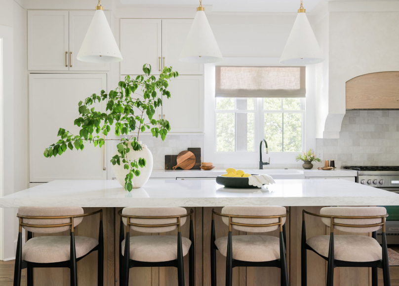 A kitchen featuring a large island, pendant lighting, and a bright open layout.