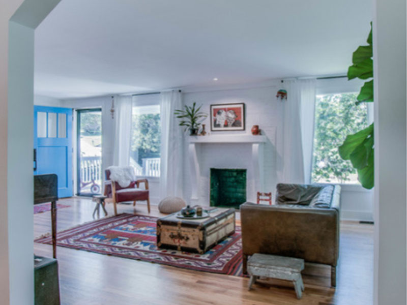 Open concept living room with fireplace and large windows.