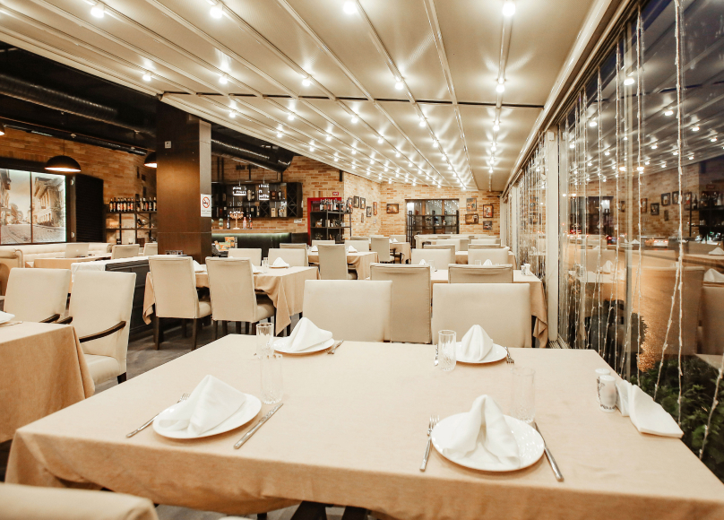 Restaurant interior with elegant table settings and overhead lighting.