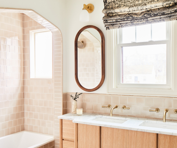 Bathroom remodel with modern wooden cabinetry, arched shower niche, and double vanity.