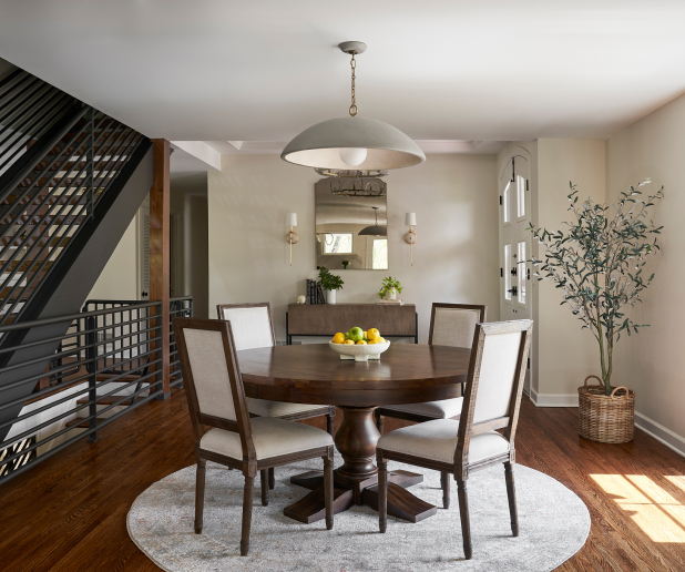 Elegant dining room with a round table, chairs, and large hanging light fixture.