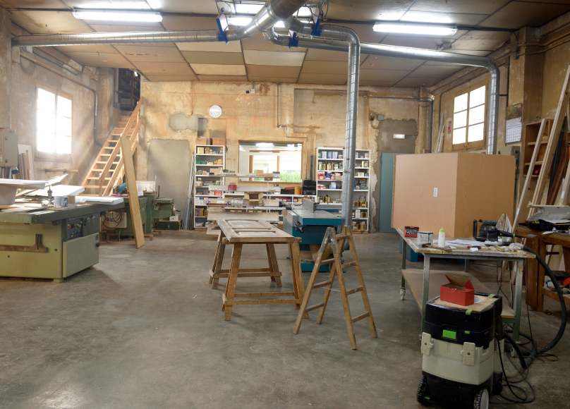 Spacious workshop with tools, workbenches, and organized shelving.