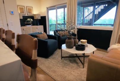 Modern living room with cozy seating, a marble table, and outdoor views.