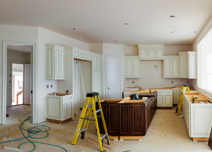 The kitchen is under renovation, with cabinets and equipment ready for installation.