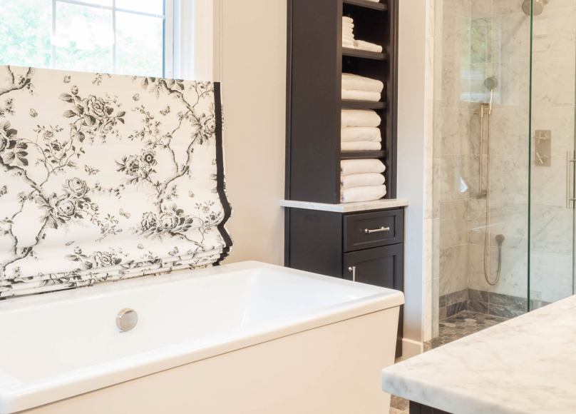 Primary bath suite with a freestanding tub, marble surfaces, and custom storage.